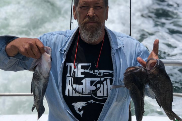 a man holding a fish in the water