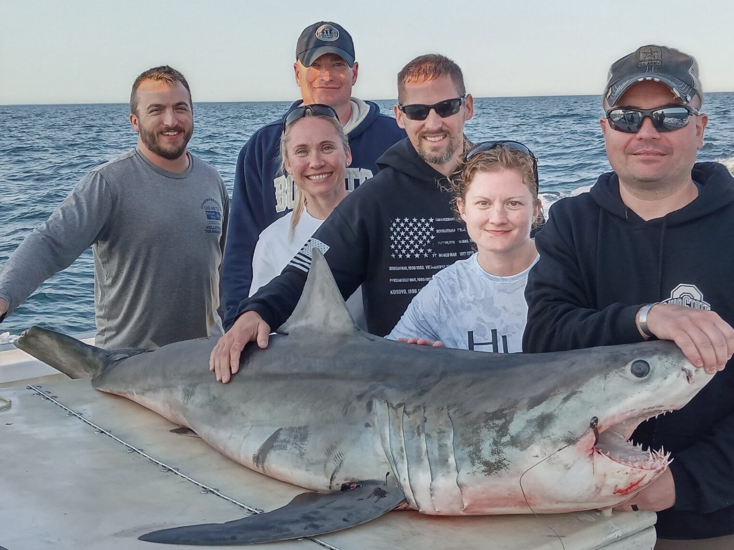 a group of people posing for a fish