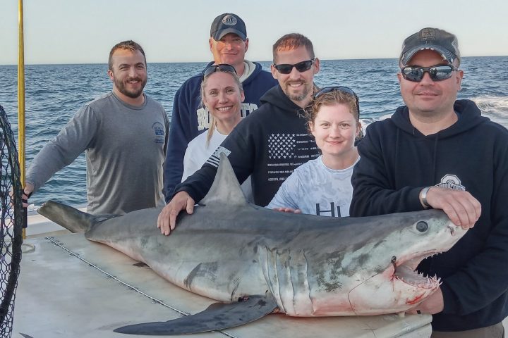 a group of people posing for a fish
