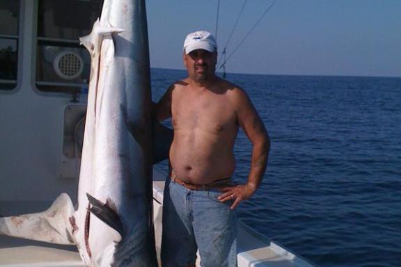 a man holding a fish in the water